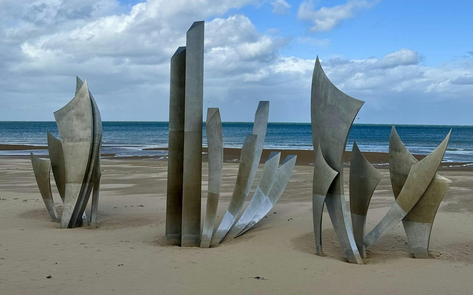 The Les Braves steel sculpture standing on the sand of Omaha Beach at Saint-Laurent-sur-Mer