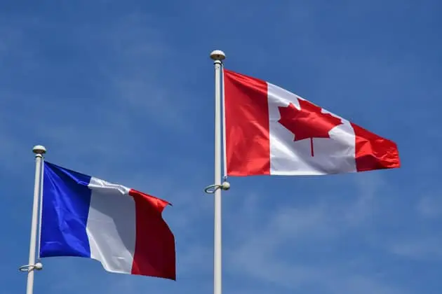 French and Canadian flags flying on the Normandy coast