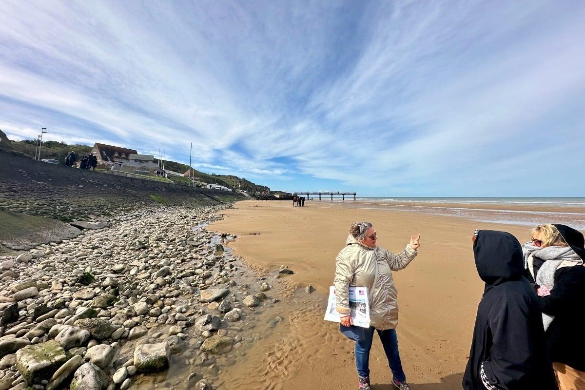 A LinkParis guide with guests on the sand at Omaha Beach